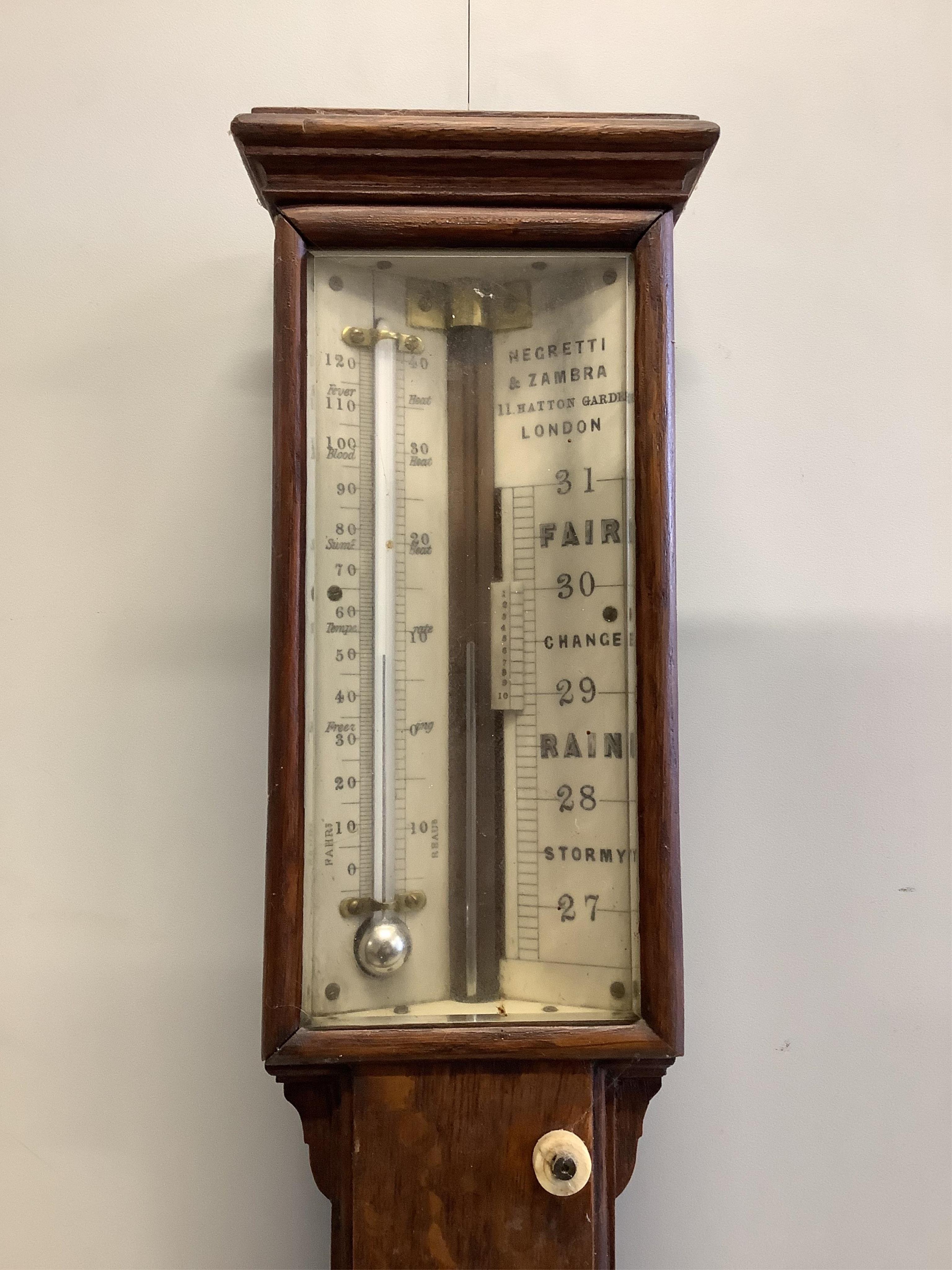 A Victorian Negretti and Zambra oak stick barometer and thermometer, with engraved bone dial, height 97cm. Condition - fair